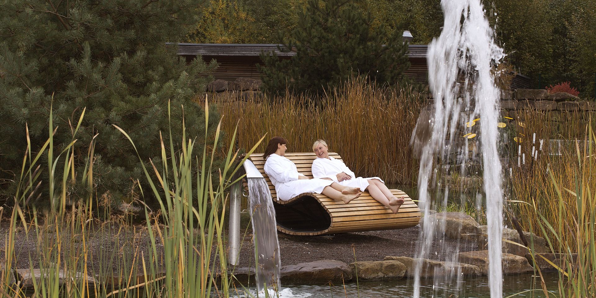 Zwei Frauen liegen auf der Paarliege am Naturbadeteich